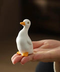Close-up of a ceramic duck from the Duck Themed Toilet Bolt Covers Set Ceramic Duck Screw Caps For Bottom Of Toilet held in hand.