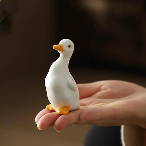 Close-up of a ceramic duck from the Duck Themed Toilet Bolt Covers Set Ceramic Duck Screw Caps For Bottom Of Toilet held in hand.