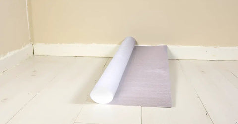 Slick And Tough Foam Underlayment Roll For Laminate And Wood Flooring With Moisture Resistant Barrier on white floor.