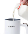 Electric Milk Frother 4 In 1 for Hot and Cold Foam One Touch Automatic Machine with milk being poured into the frother