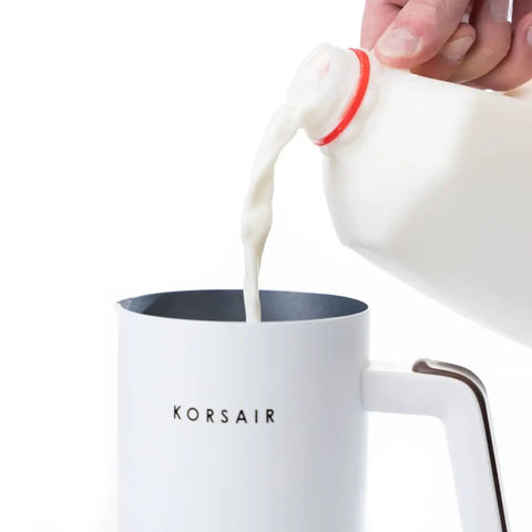 Electric Milk Frother 4 In 1 for Hot and Cold Foam One Touch Automatic Machine with milk being poured into the frother