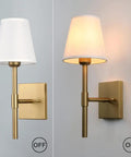 Set Of 2 Hardwired Wall Sconces With White Fabric Shade, Brass Finish Bases shown with lights off and on