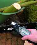 Side view of a Dremel rotary tool with a grinding stone sharpening a chainsaw chain on the bar.