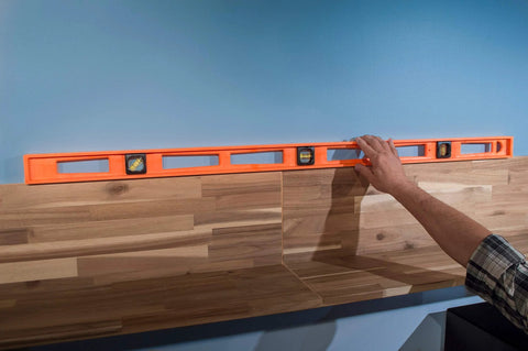 Non-conductive Structo-Cast 48 Inch I-Beam Level With Three Replaceable Acrylic Vials Delivers Precise 360-Degree Readings From Any Angle shown in use on wood paneling