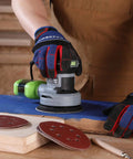 Hand using random orbital sander with 150 piece sanding discs set 5 inch 8 hole grits 60 to 600 on wood surface