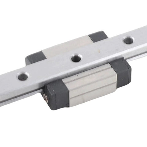 Close-up of a 100mm aluminum linear rail with sliding block and mounting holes, black end caps.
