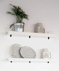 Heavy Duty 24 Pack Black Corner Braces supporting white shelves with plates and a potted plant, ideal for DIY projects.