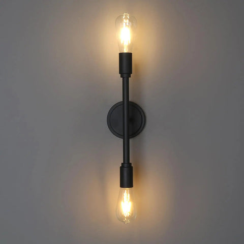 Two Light Vanity Sconce in Matte Black with E26 Base, mounted on wall with dim lighting, showcasing industrial design