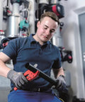 Man using Pro Grade Plastic Pipe Cutter with stainless steel blade and rubberized handle in workshop setting.