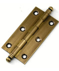 Close-up of antique brass decorative cabinet hinge with six mounting holes from set of five, smooth closing for kitchen cupboard doors.