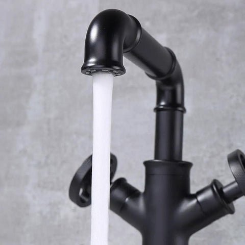 Close-up of Industrial Pipe Vessel Sink Faucet Matte Black 1-Hole 2-Handle Solid Brass Bathroom Faucet with water flowing.