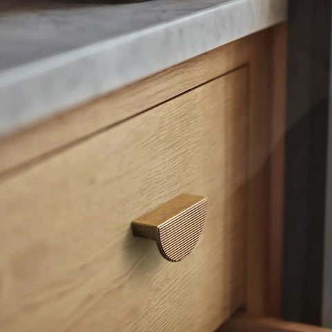 Antique Brass Zinc Alloy Cabinet Pulls 2.5 Inch Hole Center 64mm Striped Decorative Handles on wooden drawer in kitchen