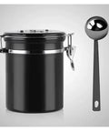 Legit Airtight Coffee Canister With Sweet Built In Scoop And Vacuum Sealed Stainless Steel Design Featuring One Way Degassing Valve Plus Handy Date Tracker Lid To Keep Your Beans Tea Or Flour Crisp And Fresh For Longer. Black stainless steel canister with an attached scoop.