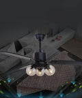 Modern Black Ceiling Fan Integrated With Glass Lamp And Remote Control above a bed with gray bedding in a stylish bedroom.