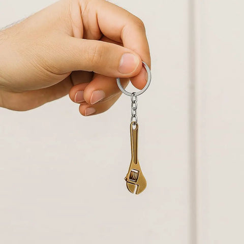 Hand holding Adjustable Wrench Keychain For Women With Realistic Copper Color Mini Tool Charm, industrial style for keys and bags.