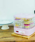 Smooth Operator Electric Food Dehydrator Machine With Five Adjustable Trays And Digital Timer, pink with dried fruits.