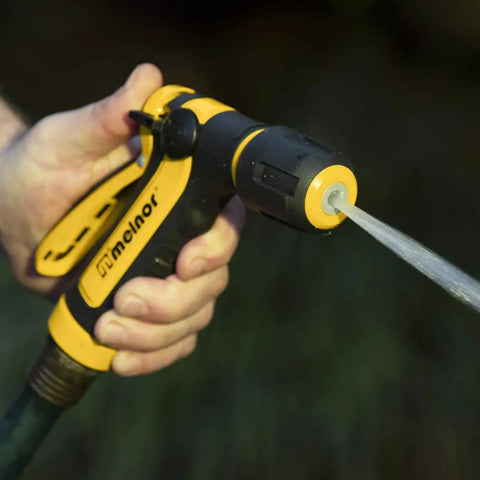 Hand holding Two Pattern Vortex Garden Hose Sprayer Nozzle With Quick Connect Adapter slip resistant grip, jet spray in action