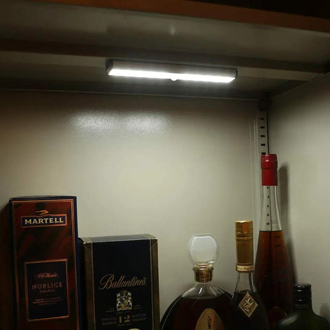 Super Bright Rechargeable Closet Lights With 78 LED Motion Sensor Night Lighting for kitchen cabinets, illuminating liquor bottles.