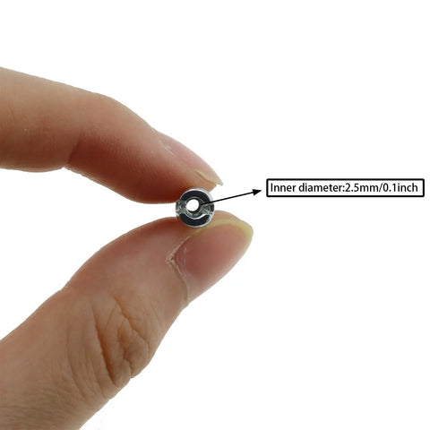 A hand holding a silver spindle with labeled inner diameter, part of 36 Pack 12mm Mountain Bike Spoke Nipples Silver for 14G Wheels.