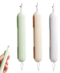 Three 2 In 1 Needle Threader And Seam Ripper tools in green, beige, white; compact design held in hand for sewing enthusiasts and seniors.