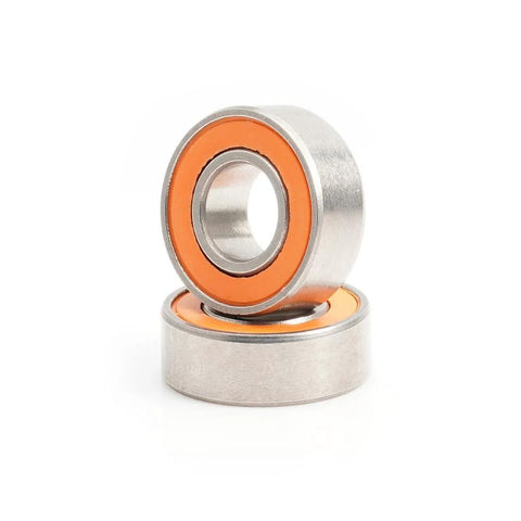 Close-up of AXK 2-piece ceramic bearing set with orange seals, includes two bearings