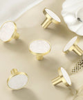 Gold and white round cabinet knobs on beige background, suitable for 12 Pack White Cabinet Knobs For Kitchen Cabinets And Dresser Drawers Drawer Pulls Easy Install Replacement Hardware Durable Smooth Finish Premium Quality Knobs For Home Renovation For Home Improvement