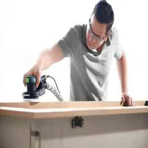 Man using 5-Inch Random Orbital Sander ETS EC 125/3 EQ-Plus Brushless EC TEC Motor with ergonomic grip on wooden surface.