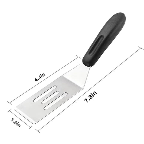 Mini stainless steel slotted spatula with black handle for flipping and serving in the kitchen