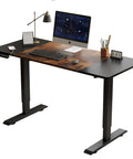 Solid Steel Frame Electric Standing Desk 55 Inches Adjustable Height Computer Table With Double Beam Structure For Home Office Gaming Setup, black and wood finish, with keyboard, monitor, and lamp.
