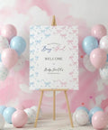 Pastel Pink and Blue Gender Reveal Balloons Set 60 Pack 12 Inch Includes 20 Pink 20 Blue 10 Pink Bow Print 10 Blue Bow Print Balloons Plus Ribbon for Easy Decorating Perfect for Baby Shower or Boy or Girl Reveal displayed beside a welcome sign on an easel at a gender reveal party.