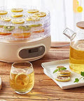 Compact Electric Food Dehydrator Machine For Fruit Jerky And Herbs With Five Stackable Trays Digital Timer Precise Temperature Dial No Fuss Setup Kitchen Game Changer with dried fruits and herbal tea.