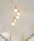 Top Shelf Three Head Disc Pendant Ceiling Light With Milky Frosted Glass Lampshades And Heavy Duty Wrought Iron Frame hanging above stairs