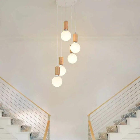 Top Shelf Three Head Disc Pendant Ceiling Light With Milky Frosted Glass Lampshades And Heavy Duty Wrought Iron Frame hanging above stairs