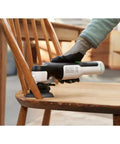 Eco Friendly Cordless Oscillating Multi Tool With 12V Max Muscle And Rapid Blade Swap Mechanism cutting wood on a chair.