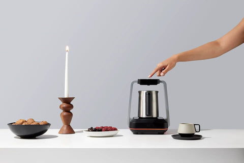 Person using Turkish Coffee Maker Electric With Open Form Design For Watching Foam Rise And Savoring Aroma SandBrew Technology