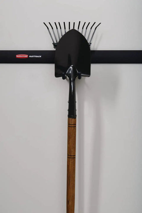 FastTrack Rail Garage Organization System With Multi-Purpose Hooks holding a rake and shovel on a wall-mounted rail