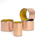 10 Piece Set Of SF 2 Self Lubricating Copper Bushings Oilless Bronze Bearings 25 X 28 X 40 Mm stacked with varying sizes.