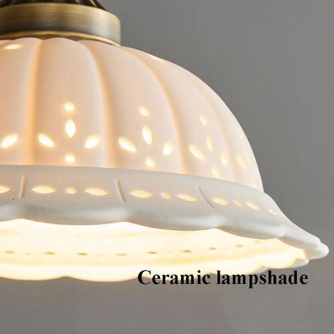 Ceramic Wall Sconce, 9 Inch Brass Vintage Light with floral cutout white porcelain lampshade showcasing warm glow.