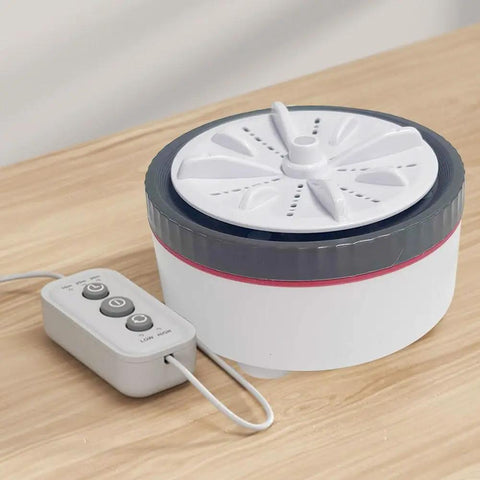 No Sweat Portable Mini Turbo Washing Machine With Steady Grip Base For Daily Baby Laundry And Underwear Lightweight Micro Usb Rechargeable Compact Countertop Cleaner on a wooden surface with control panel.