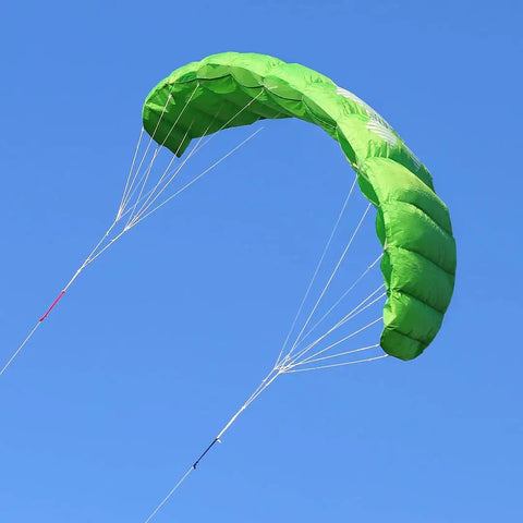 Green Fluxx 1.8 R2F Trainer Kite for Beginners with attached flying lines in stable flight against clear blue sky.