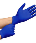 Cobalt blue nitrile disposable gloves, pair being worn in a close-up view.