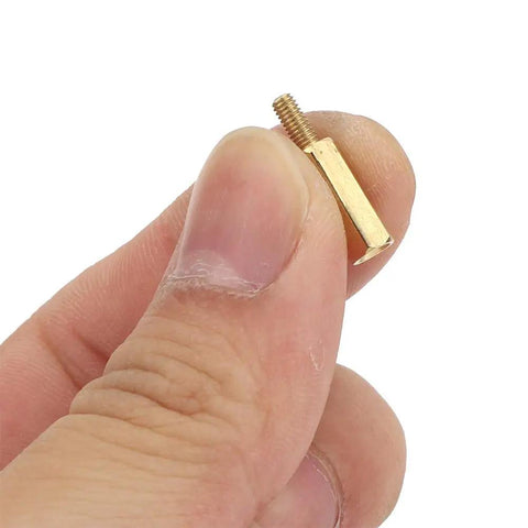Brass Spacer Kit For Electronics And 3D Printer Mounts, 180-Piece M2.5 Hardware Set With 10 Female-Female Spacers, 10 Male-Female Pillars, 50 Screws, 50 Nuts, Oxidation-Deterrent Brass For Precise Component Spacing And Do It Yourself Builds. brass spacer held between fingers