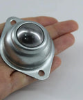 One Inch Flange Mount Ball Transfer Bearing held in hand, showcasing its durable carbon steel build, ideal for smooth conveyor setup.