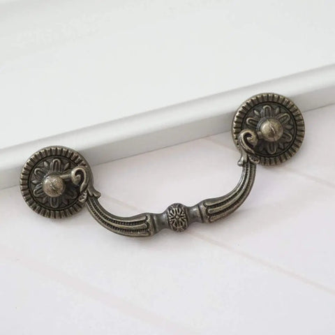 Knockout Antique Bronze Drop Bail Dresser Pull With 3 Inch Hole Centers Rustic Cabinet Handle shown on a light background.