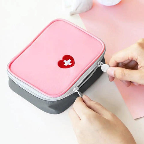 Pink Mini Outdoor First Aid Kit Bag For Travel And Everyday Use with zipper being opened, showing heart symbol on front.