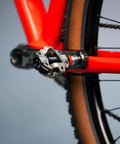 Single Sensing MTB Power Meter Pedal For Left Side, 100 Percent SPD Compatible, attached to a red bike frame