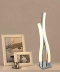 LED Table Lamp For Bedroom With Touch Dimmable Brightness And Memory Function Modern Arc Silver Desk Light beside photo frames