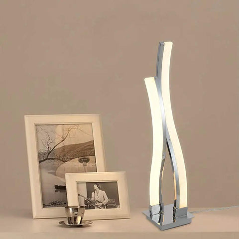 LED Table Lamp For Bedroom With Touch Dimmable Brightness And Memory Function Modern Arc Silver Desk Light beside photo frames