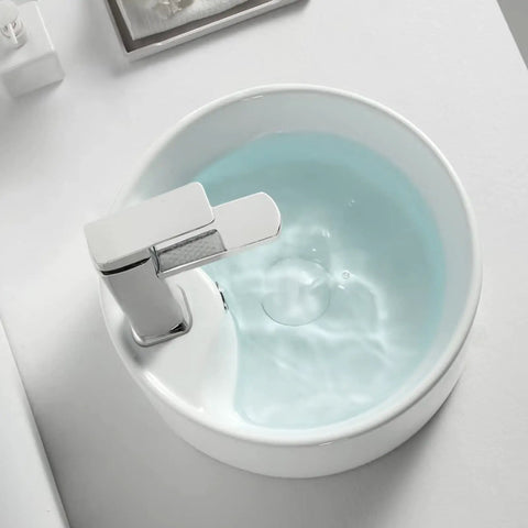 Straight Fire 15.7 Inch Diameter Round Ceramic Bathroom Vessel Sink With Integrated Faucet For Above Counter Installation And Quick Room Glow Up In Crisp White Finish, showcasing water reflecting light.