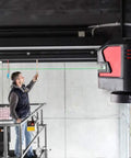 Knockout Green Beam Cross Line Laser Level For Hella Visible Layout Marks And Super Sharp Wall Grids With Effortless Drywall Tiling Setup On Tough Jobs projecting a green line on a wall.